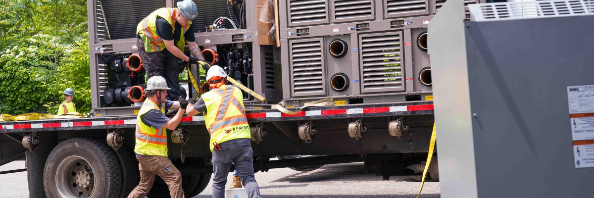 Construction workers are unloading a new HVAC system for a deep retrofit.
